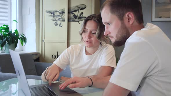 Stay home. Beautiful couple at home. Man work at home, he is in freelance during quarantine  alt