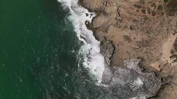 Stormy sea with waves breaking, white foam and beach sand dragged into the sea - Winter weather at s