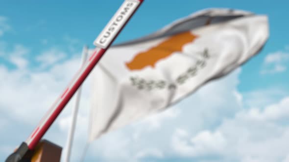 Closing Boom Barrier with CUSTOMS Sign Against the Cypriot Flag alt