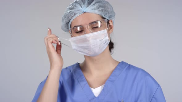 Cheerful Female Doctor Taking off Mask and Posing alt