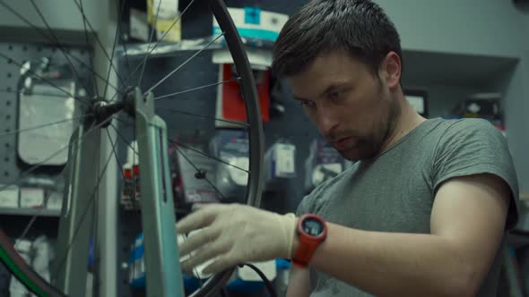 Professional Bicycle Mechanic Adjusting One Spoke at Time Special Tool for Tensioning Spokes alt