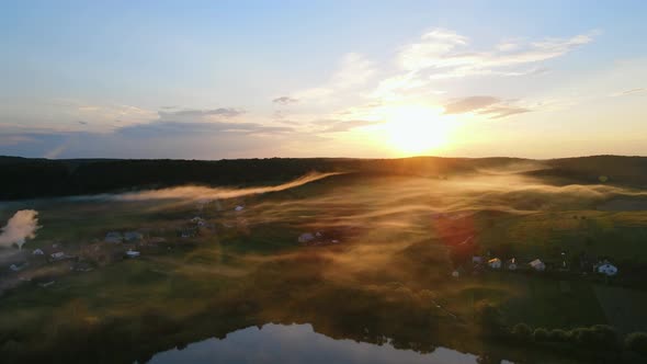 Evening Fog Descends on the Lake and a Small Village at Sunset alt