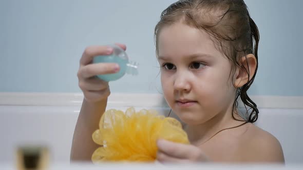 a Teenage Girl in the Bath Pours Baby Shampoo From a Bottle on a Washcloth