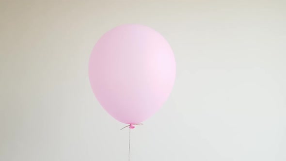 Light Helium Balloon in Pink Floating Against Off White Wall Celebration Birthday Concept alt
