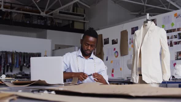 Mixed race man working in fashion office alt