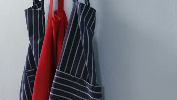 Various aprons hanging on hook 4k alt