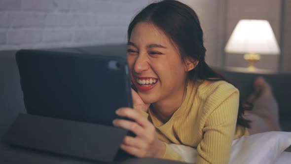 Young Woman Using Digital Tablet Watching an Entertainment Movie Series at Home alt