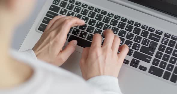 Female fingers are typing text on the laptop keyboard. Business woman works using a computer.