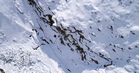 Aerial Overhead Flying Moving Forward Over Snowy Mountain Ridge Valley Establisher