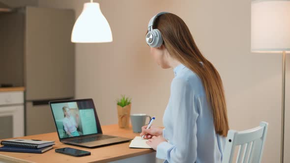 Distance Education Young Female Student Sits at a Desk at Home and Study Online Using a Laptop