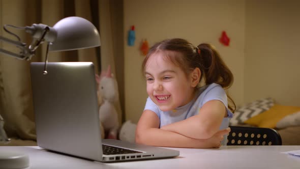 Cute Preschool Girl Watching Movies or Educational Videos on a Laptop alt