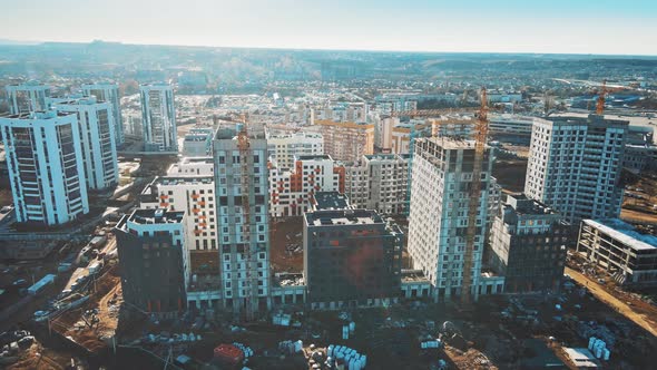 High crane works on building site with a house. alt