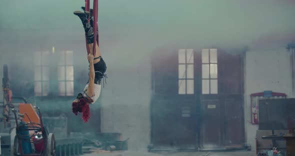 Aerial Gymnastics in a Smoky Hangar Woman in the Red Ropes alt
