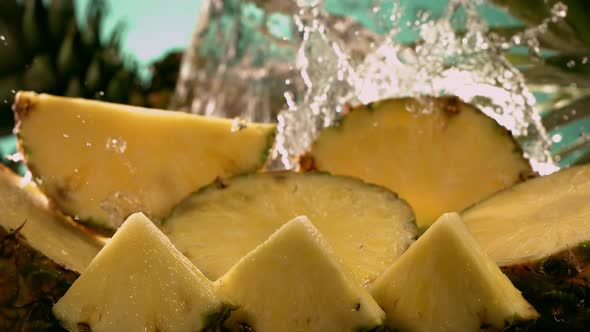 Slow Motion Shot of Pineapple and Water Splashing Through Pineapple Slices alt