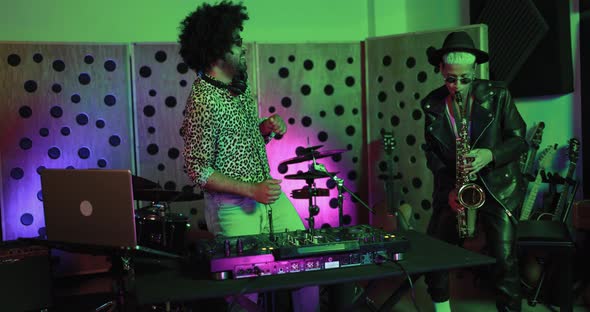 Dj and female saxophone musician playing music inside boutique recording studio alt