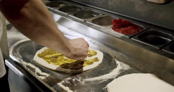 The chef prepares fresh pizza in the restaurant kitchen. Italian pizza. alt