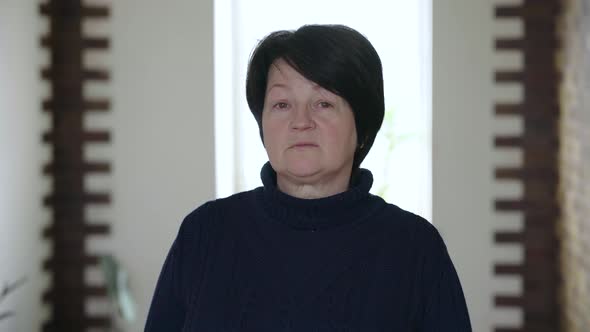 Portrait of an Elderly Woman with Wrinkles on Her Face Looking Forward