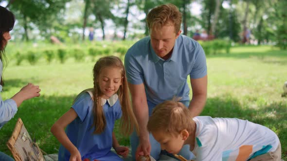 Happy Family Preparing Picnic in Park alt
