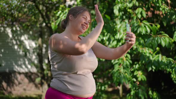 Side View Joyful Plussize Woman Waving at Smartphone Video Chat Talking in Slow Motion alt