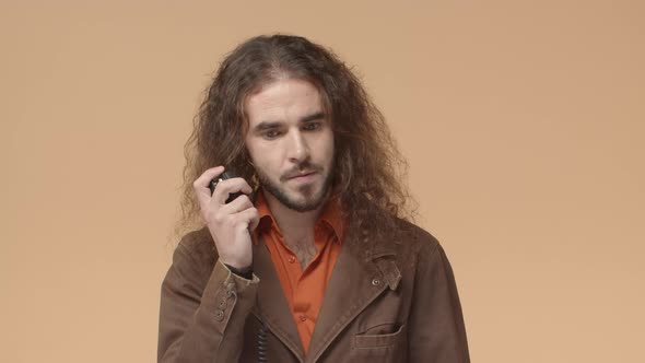 Seriouslooking Bearded Man with Long Hair Listening to Question Over Transmitter Using Radio Set to alt