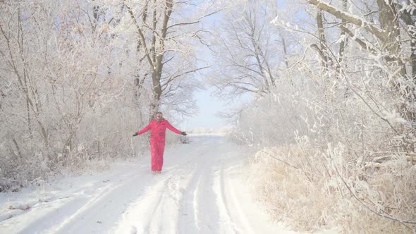 A Man Walks Through a Winter Forest with Snow Covered Trees on a Beautiful Frosty Morning alt