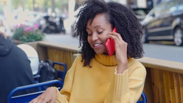 Smiling Brazilian Woman Drinking Coffee and Talking on the Phone on the Terrace alt