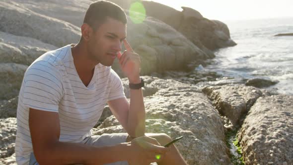 Man using mobile phone on beach in the sunshine 4k alt