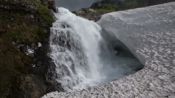 Bottom view of High Waterfall Falling in Snowfield