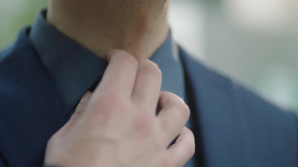 Businessman is Getting Rattled and Loosing Nervously the Tie with His Hand alt