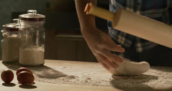 Male Hands Roll Out Pizza Dough with a Rolling Pin