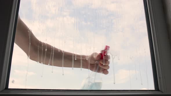 A Man Washes a Window From the Outside