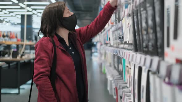 Girl in Black Medical Mask Buys USB Flash Drive in Shop
