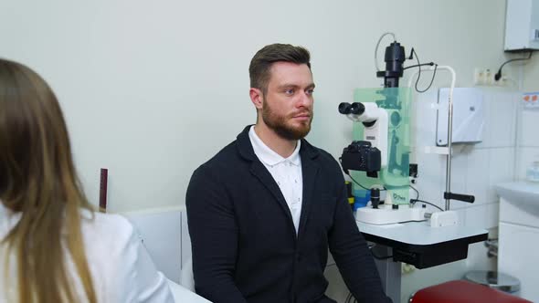 Patient during vision test. Young male patient checking up vision, closing his eye alt