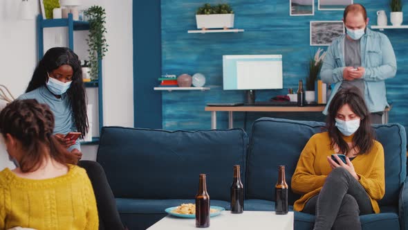 Multiethnical Friends with Protective Masks Browsing on Smartphones alt