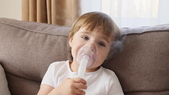 Little Girl Holding a Mask Nebulizer Inhaling Fumes Medication Into Lungs alt
