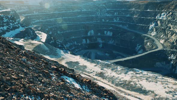 Massive Mine Pit with a Bit of Snow in Sunlight alt