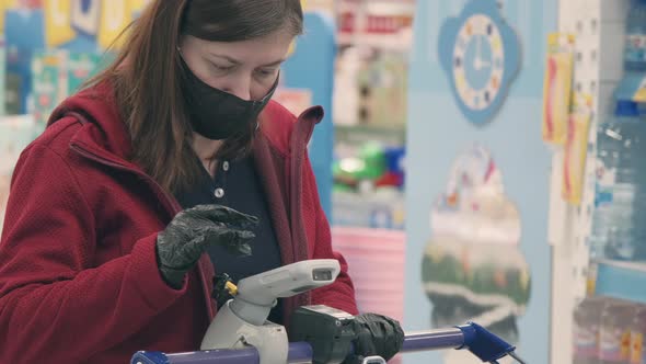 Girl in Mask and Gloves Against Virus Makes Contactless Purchase Goods in Shop alt