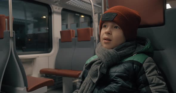 Boy riding on a commuter train alt
