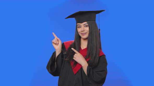Portrait of Female Student in Graduation Costume Pointing Side Hand for Something Then Nods and alt