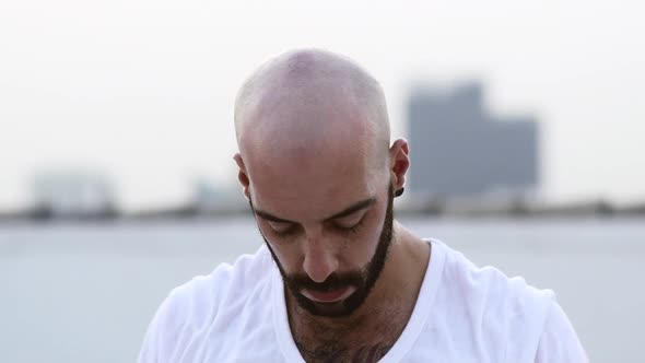 Bearded Man Stretching His Neck By Slightly Turning It From Side To Side alt