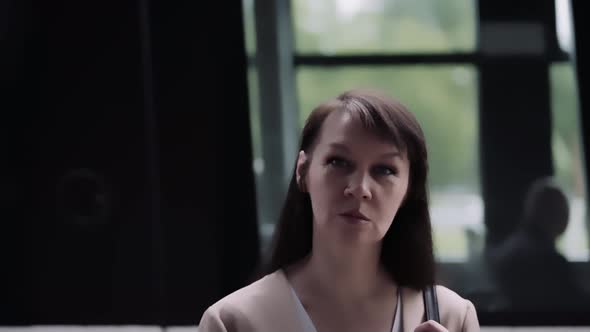 Portrait of a woman in front of a departing tram. public transport in movement. alt