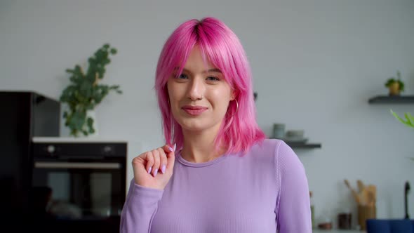 Portrait of Elegant Pretty Pink Haired Woman Looking with Cheerful Smile Indoors alt