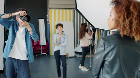 Slow Motion of Professional Photographer Taking Pictures of Model in Studio alt