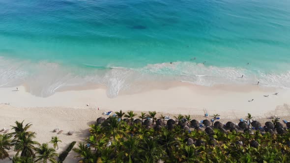 Drone View of a Tropical Beach with People Relaxing and Swimming alt