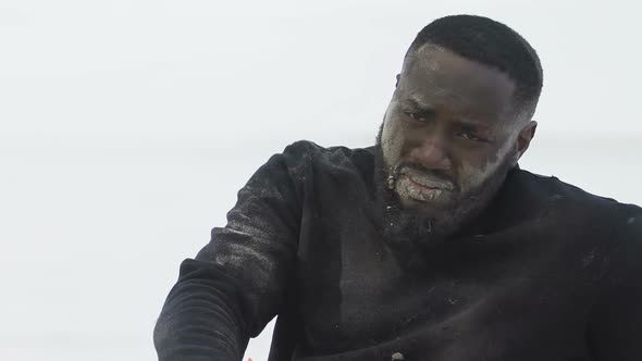 Deeply Sad Afro-American Man Hugging Life Vest, Plane Crash Survived Victim alt