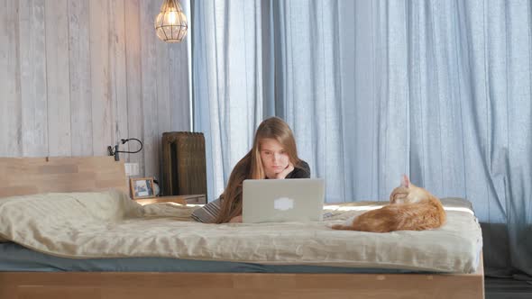 Young Millennial Woman Surfing Internet on Laptop at Home.