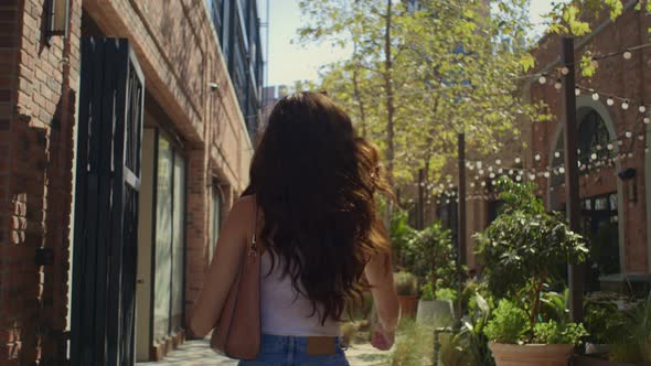 Tranquil Woman Strolling on Street Back View alt
