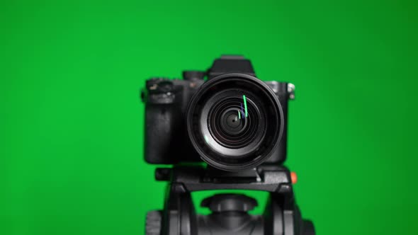 Professional DSLR Photo Camera with Lens at Green Background