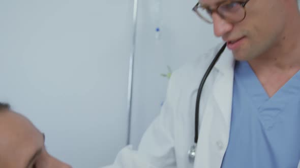 Close-up of Caucasian male doctor talking with female patient in the ward at hospital 4k alt