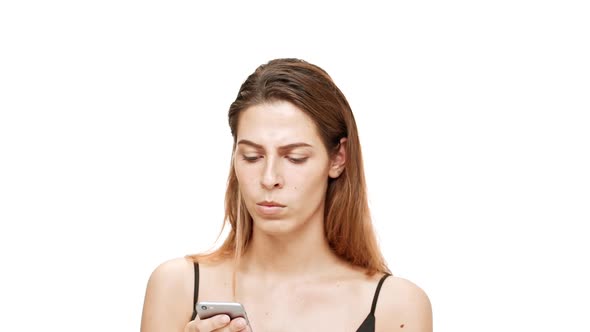 Displeased Young Beautiful Girl Looking at Phone Over White Background alt